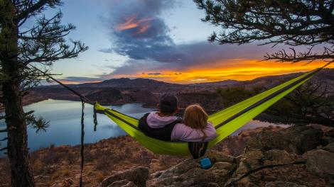 Couple admirant le rougeoiement du coucher de soleil dans un hamac avec vue sur Horsetooth Reservoir
