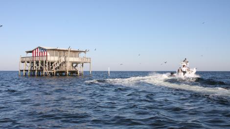 Red White and Blue Stilt House with Boat