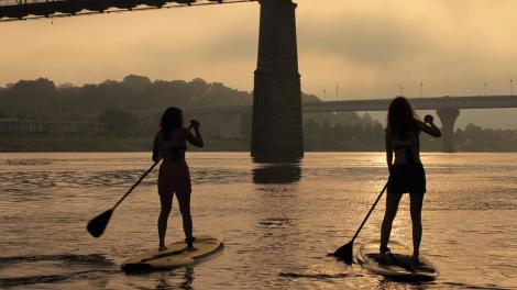 Paddle boarders on the Tennessee River head toward the Walnut Street Bridge