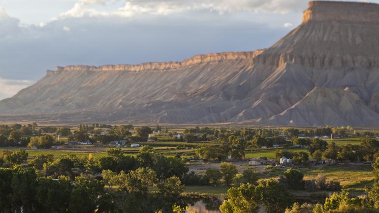从科罗拉多州帕利塞德的 High Country Orchards and Vineyards 葡萄园欣赏书崖山脉的美景。