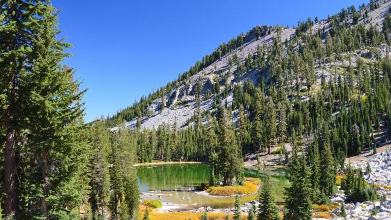 The Pacific Crest Trail cuts through Lassen Volcanic National Park, in northeastern California. Spiny fir trees and clear mountain lakes contrast with the desert landscape seen at the start of the movie "Wild."