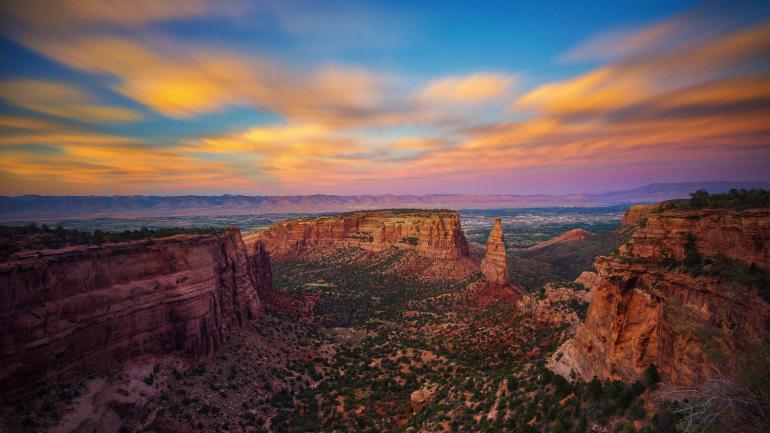 大章克申附近科罗拉多州国家纪念公园红色岩石上方的日出美景