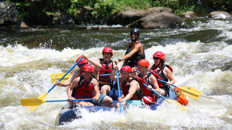 Paddling through the rapids on a white water rafting trip down the Pigeon River