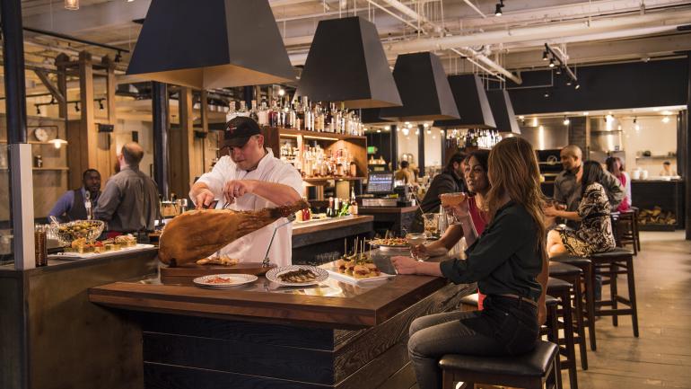 在 La Cuchara 餐厅，客人可以一边品尝巴斯克风味小吃，一边观看厨师切伊比利亚火腿。