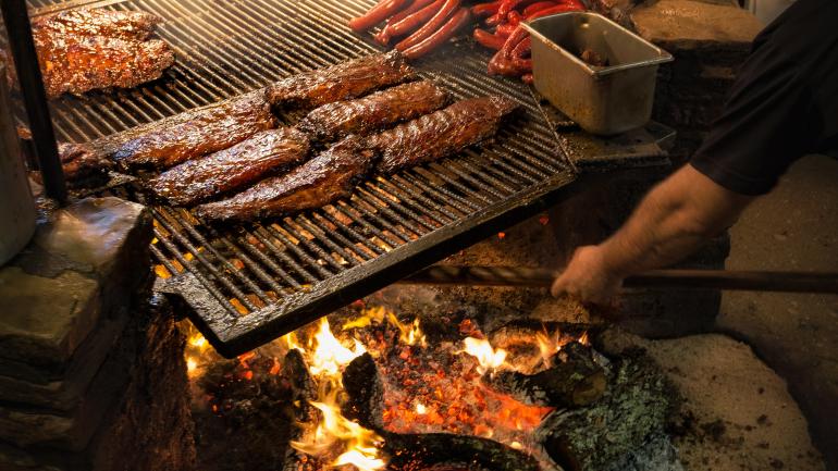 Grilling meats low and slow over a flame at The Salt Lick BBQ