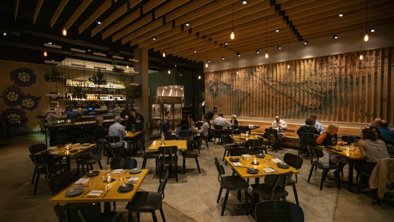 在以路易斯安那州和越南壁画为背景的 Maypop 用餐