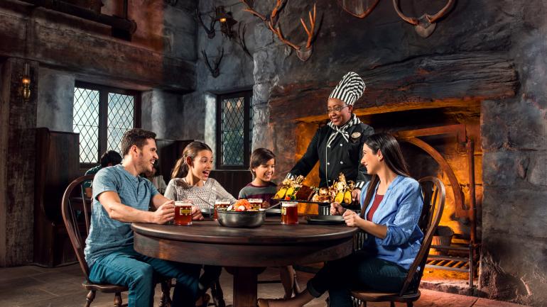 一家人在 The Wizarding World of Harry Potter™ 的 Three Broomsticks™ 用餐 一家人在 The Wizarding World of Harry Potter™ 的 Three Broomsticks™ 用餐