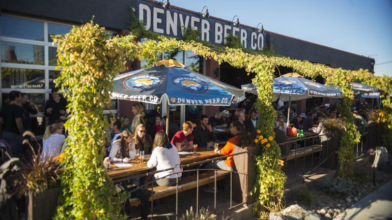 顾客们在 Denver Beer Co. 酿酒厂的露台上度过美妙时光