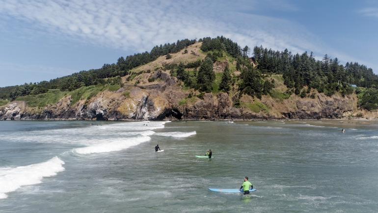 享受俄勒冈州纽波特 Agate Beach 海滩海浪的冲浪者
