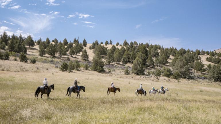 在俄勒冈州弗斯镇威尔逊农场度假村 (Wilson Ranches Retreat) 广阔的原野上骑马