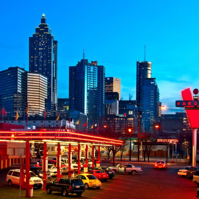 Varsity 汽车餐厅以及在佐治亚州亚特兰大市中心的城市天际线下闪烁着餐厅的霓虹灯