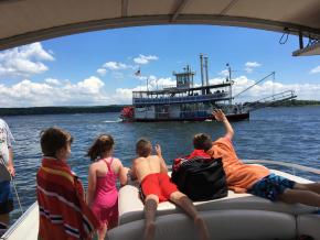 向登上肖托夸湖上的 Chautauqua Belle 明轮船巡游的乘客挥手 向登上肖托夸湖上的 Chautauqua Belle 明轮船巡游的乘客挥手