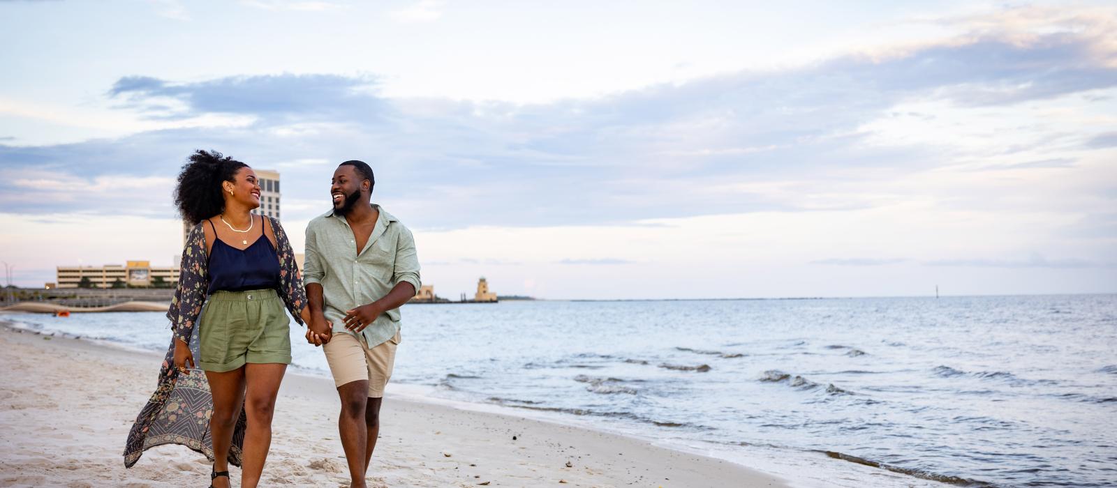 一对夫妇在密西西比州比洛克西的海滩上悠闲散步