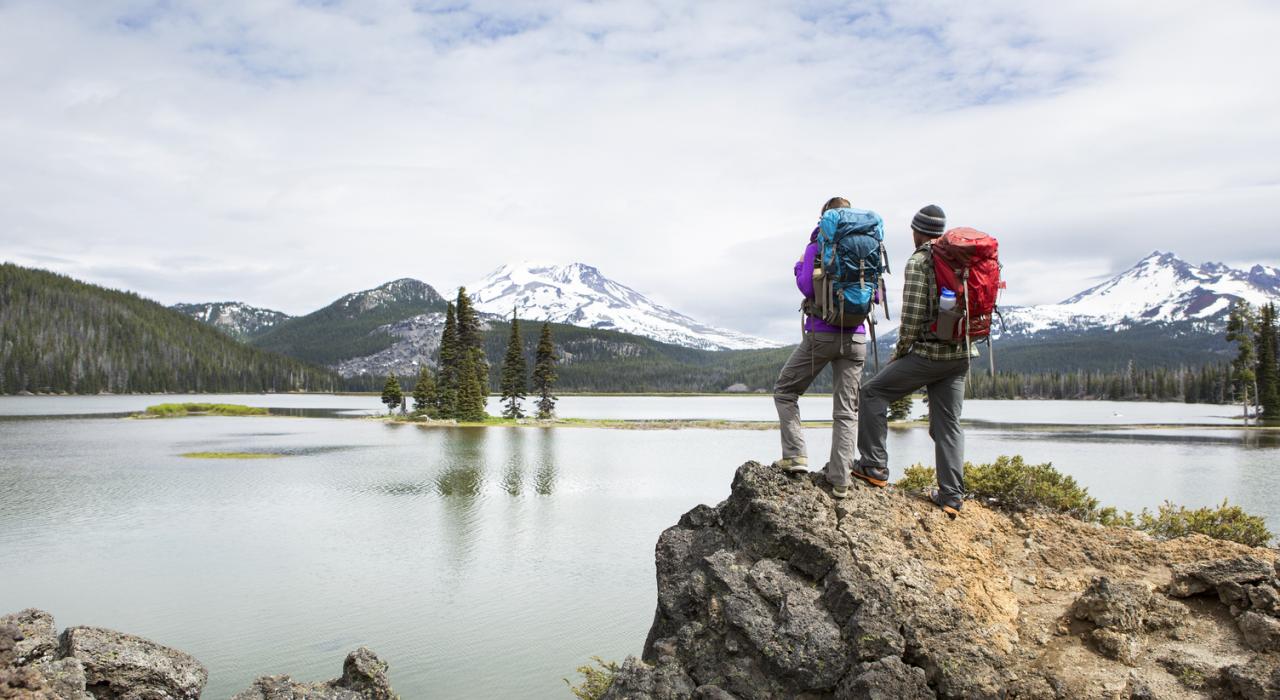Backpackers looking out at mountain range in Oregon