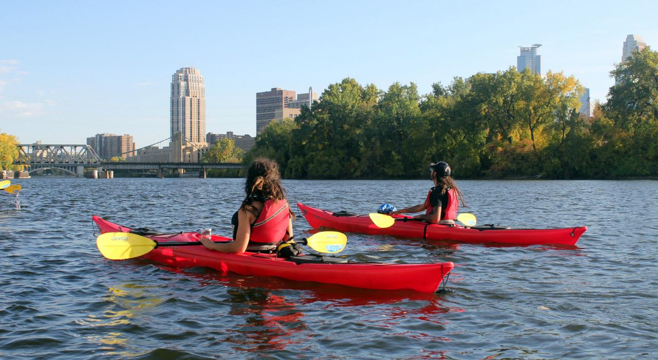 在市区附近瀑布上方的水道划皮划艇