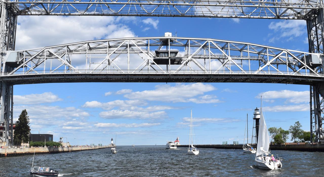 Sailboats pass underneath the Aerial Lift Bridge