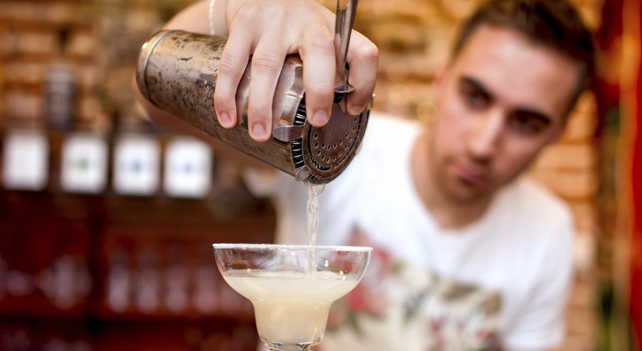 Man pouring cocktails from a shaker