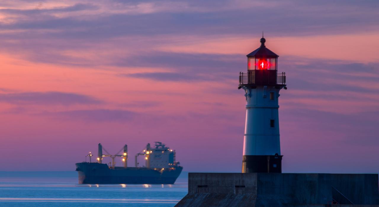 Sunrise paints the harbor while North Pier Lighthouse looks on