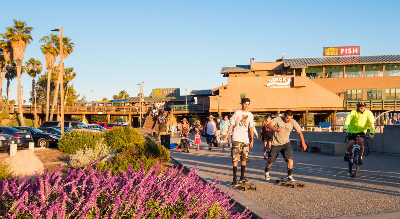 在文图拉码头的海滨大道上玩滑板、骑自行车和漫步