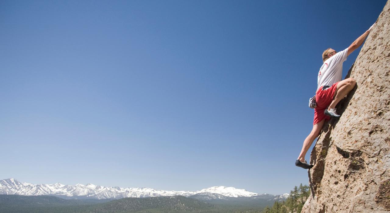 在山间高处攀登的无畏攀岩者