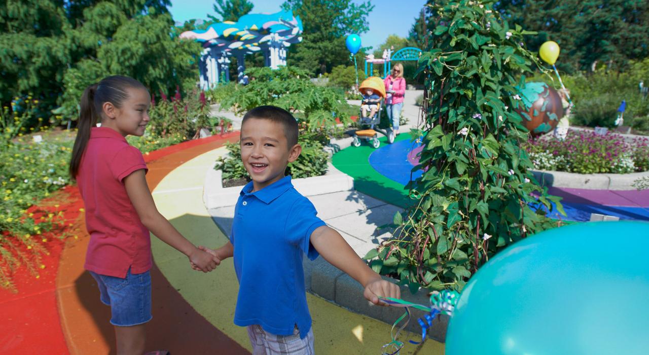 孩子们在 4-H Children's Garden 儿童游乐园内欣赏植物和表演