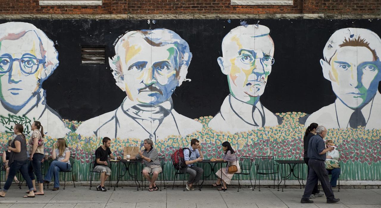 Chatting in the shadows of giants depicted in The Bookstore Mural
