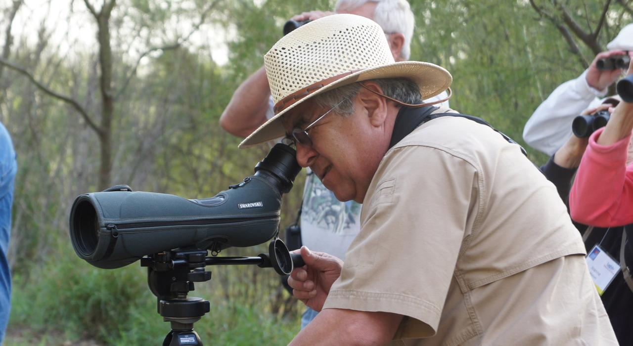 周囲に生息する多数の珍しい鳥類を観察するバードウォッチャー