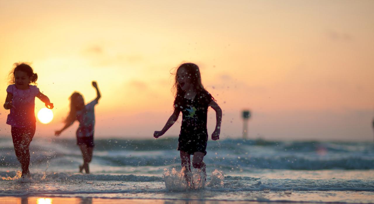 Children playing in the surf at sunset near St. Petersburg, Florida