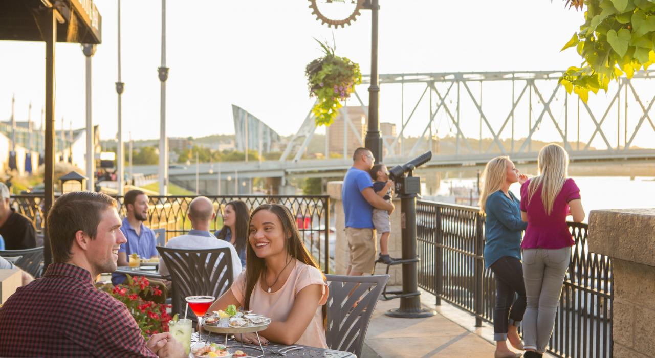 在 Newport on the Levee 娱乐中心享受露天餐饮，欣赏迷人水景