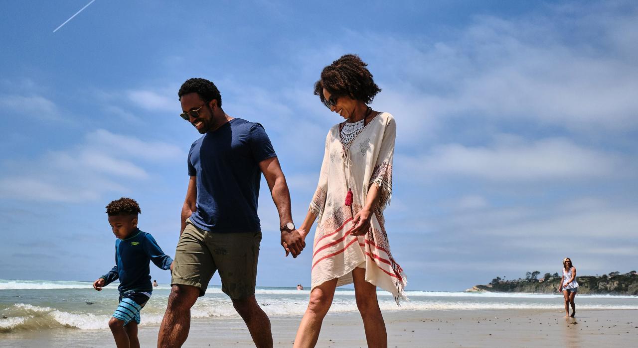 在盐溪海滩赤足漫步享受天伦之乐的一家人