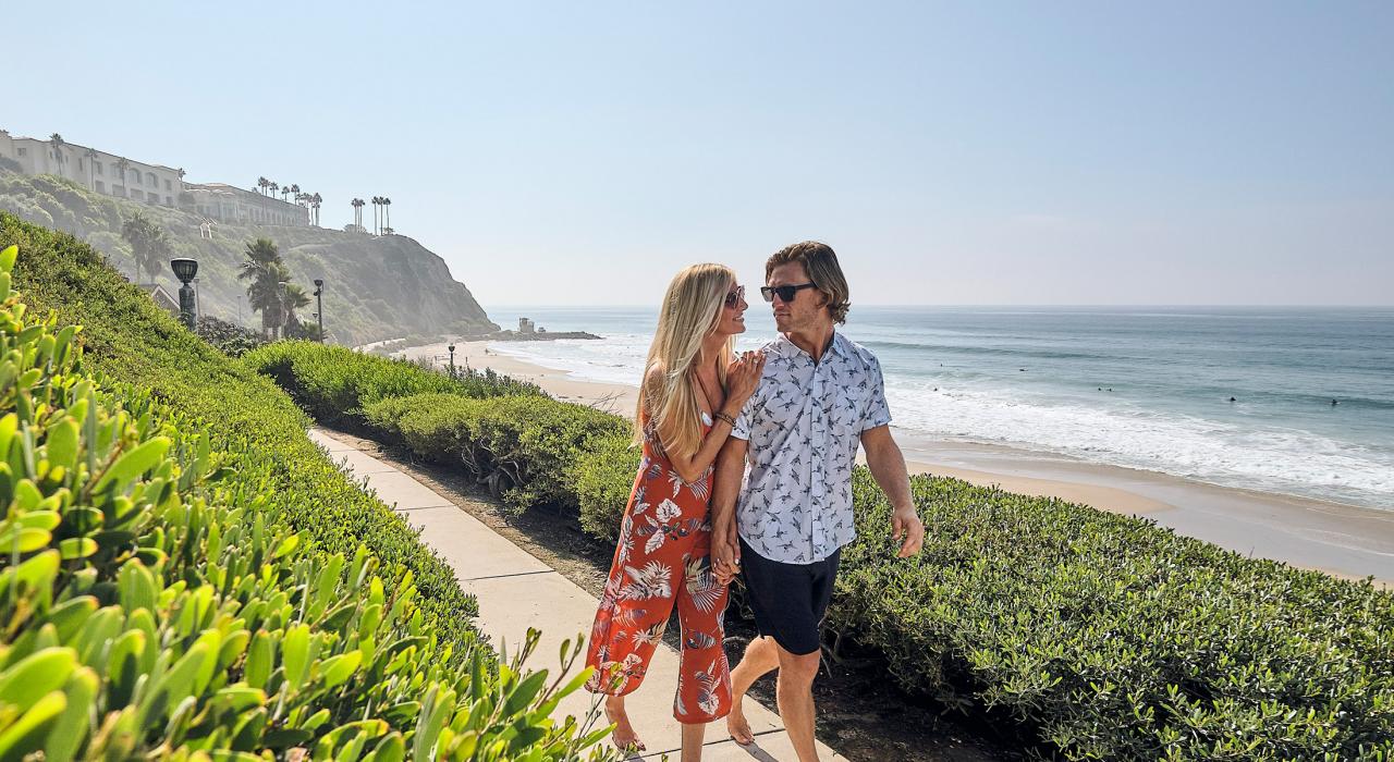 一对爱侣沿着小径漫步，从这里可以眺望盐溪海滩