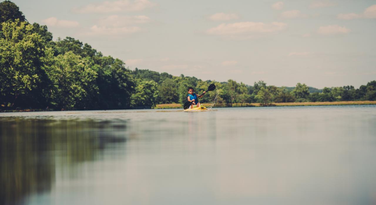 在亚特兰大湖 (Lake Atalanta) 平静的湖面上划皮艇