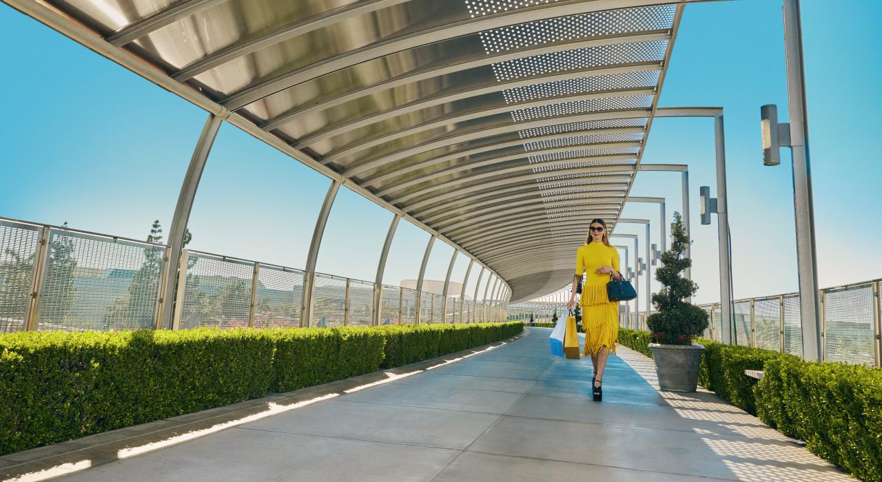 手拿购物袋穿过南海岸广场的联合桥