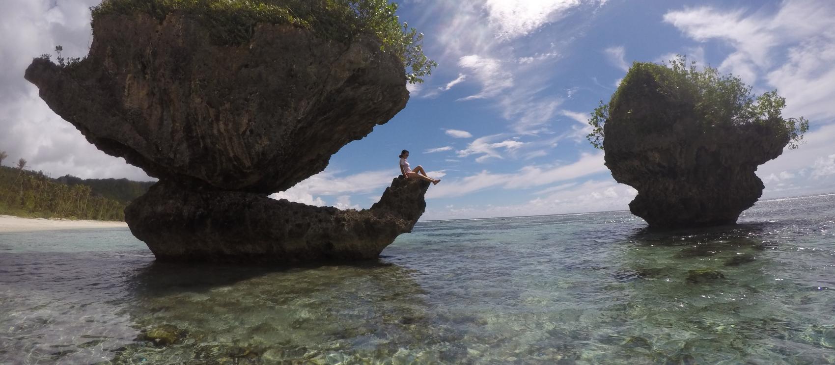 在蘑菇岩上休息的女游客