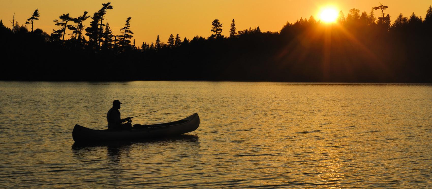 夕阳西下，在边界水域乘独木舟垂钓